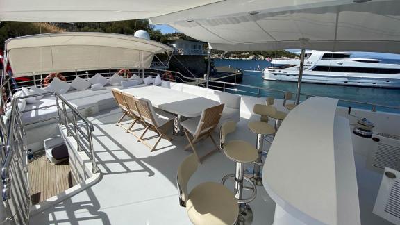 Spacious sun deck with seating area and bar on yacht Gül Maria